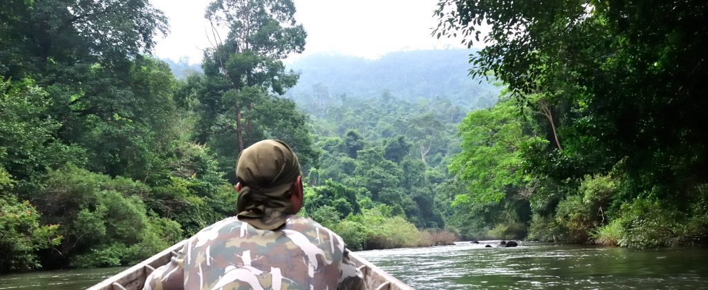 Traveling up the Amazon river in a small boat.