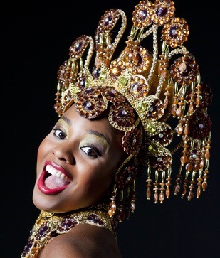 A woman poses for a photo in her carnival dress.