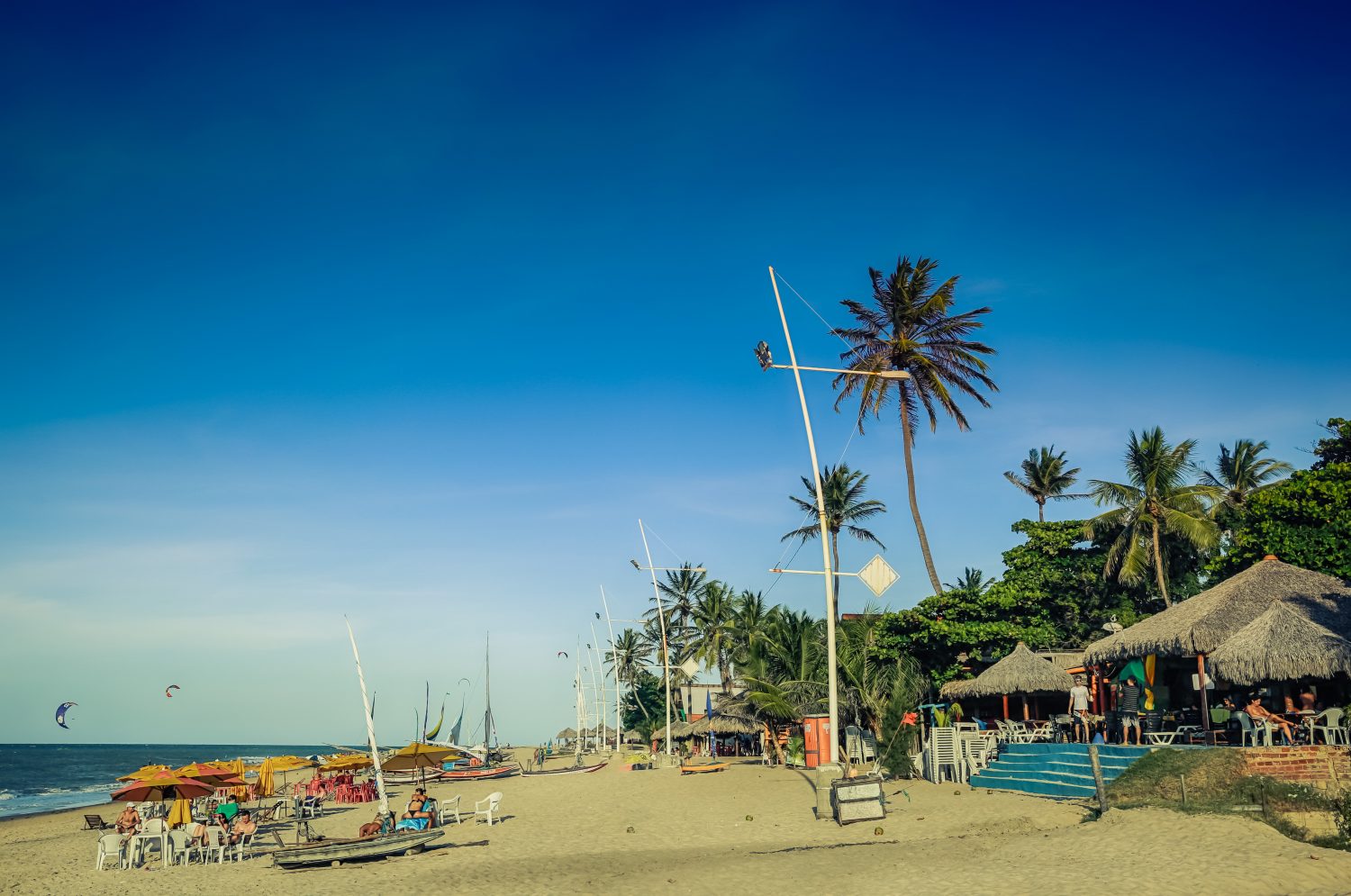 The beach at Guajiru, a blue sky with colourful kites flying. 