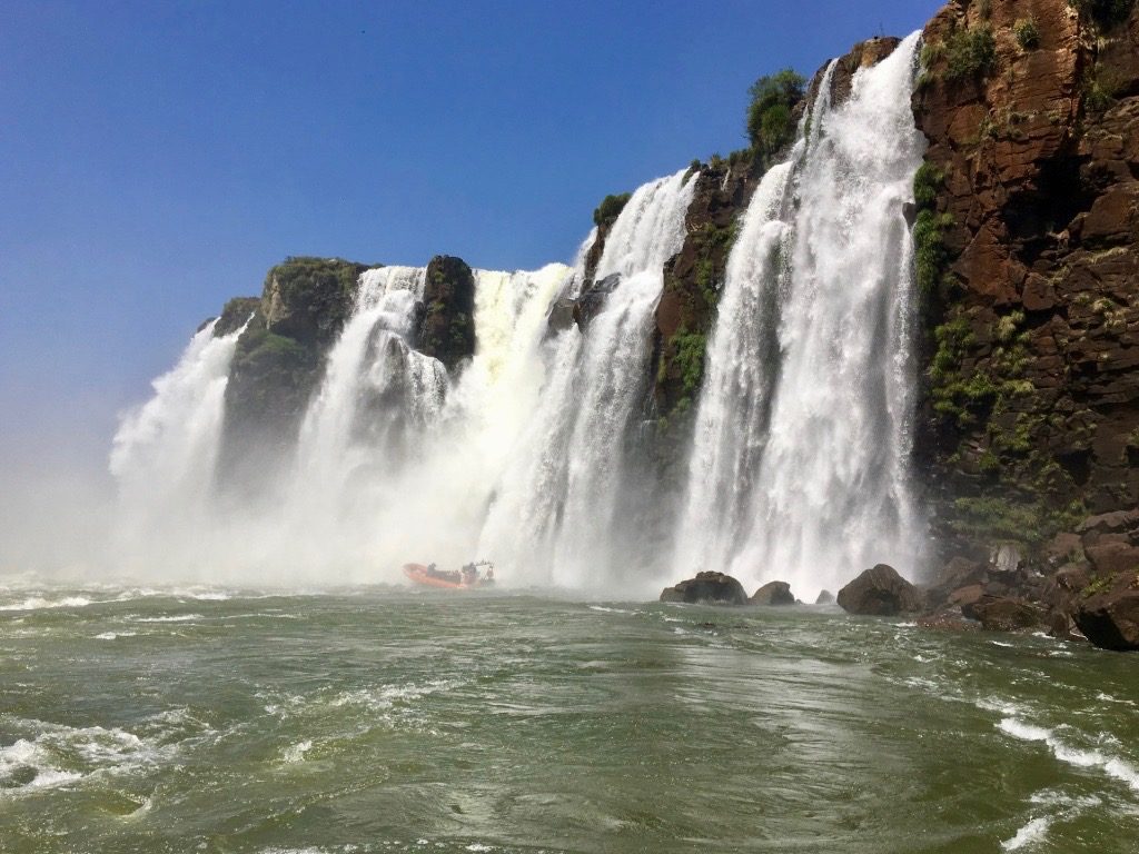 The macuco safari bringing some tourists right underneath the falls!