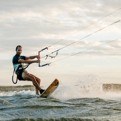 Kitesurfer rides a surf style board.