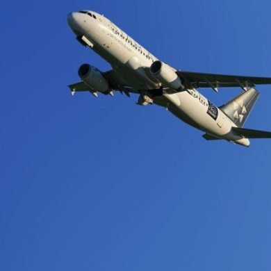 Two commercial airplanes flying, with a blue sky in the background.