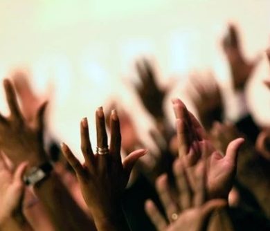 Image of people raising hands in prayer in a Protestant ceremony.