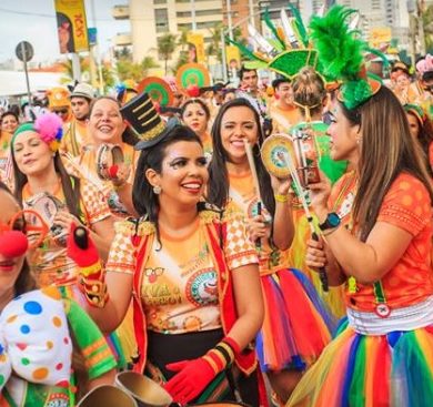 A crowd dressed in orange parades at pre-carnaval in Fortaleza.